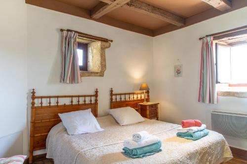Un dormitorio con una cama con toallas. en Tour Pissarro, en Beynac-et-Cazenac