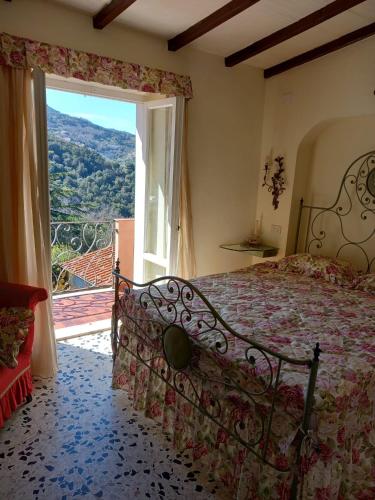 une chambre avec un lit et une grande fenêtre dans l'établissement Nora's House Elba Island, à Marciana