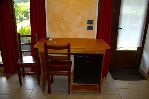 a kitchen with a wooden table with chairs and a dishwasher at Arthemisia in Rhêmes-Notre-Dame