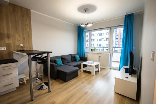 a living room with a couch and a table at Apartament Strefa Czasu in Toruń