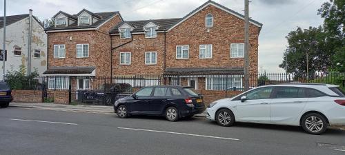 two cars parked in front of a brick building at Hall 3 in Amley