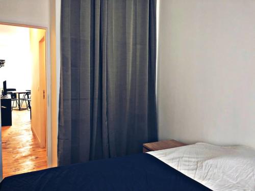 une chambre avec un lit et une fenêtre avec des rideaux dans l'établissement Charmant T2 cosy à deux pas du centre, à Bayonne