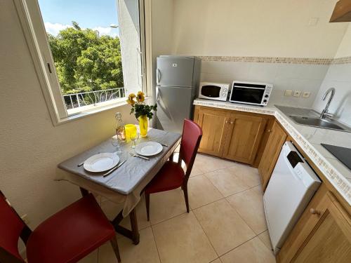 a small kitchen with a table with two chairs and a window at *.* Haut de villa U Nespulu di Anghjulina *.* in Borgo