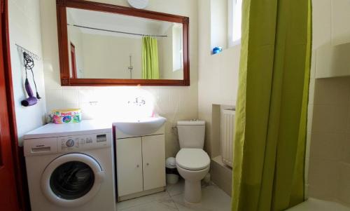 a bathroom with a toilet and a sink and a washing machine at Willa Rybitwa in Gdynia