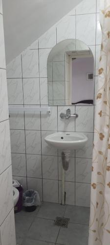 a white bathroom with a sink and a mirror at Central city AP in Sibiu