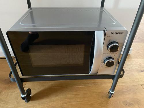 a silver toaster oven sitting on a stand at Beautiful Apartment with a huge private terrace 