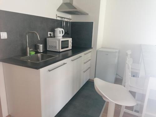a kitchen with a sink and a microwave at Brand new two room apartment #64 in Elite Rezidence with free secure parking in Prague