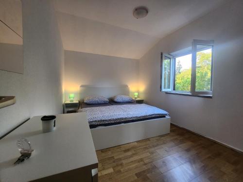 een kleine slaapkamer met een bed en een raam bij Holiday House Dunamis in Krivodol