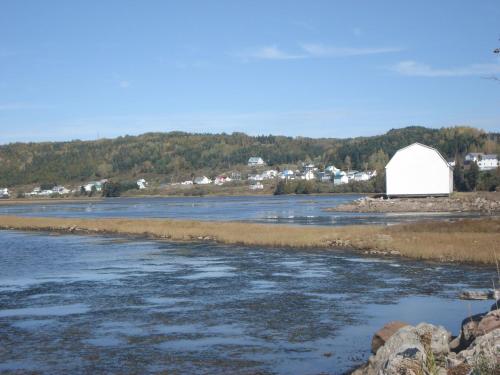 a white barn in the middle of a river at Motel de l'anse in Port-Daniel