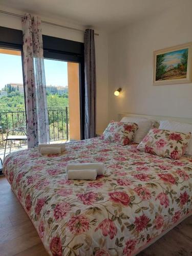 a bedroom with a bed with a floral bedspread at Villa Vallese Bale in Bale