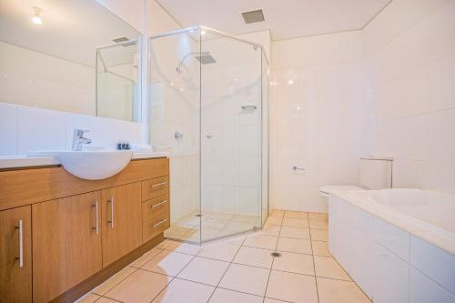 a bathroom with a shower and a sink and a tub at Wallaroo Marina Apartments in Wallaroo