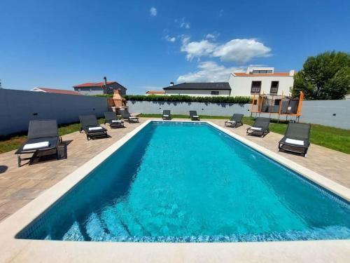 una piscina con tumbonas y sillas alrededor en Villa Vallese Bale, en Bale