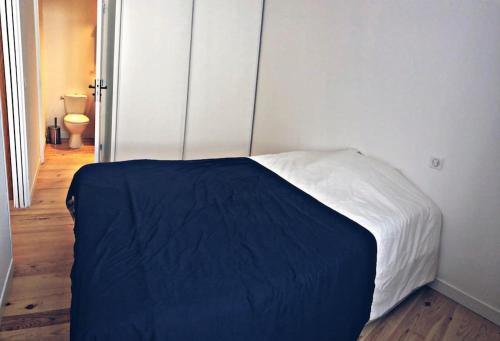 - une chambre avec un lit doté d'une couverture bleue dans l'établissement Agréable T2 cosy proche du centre de Bayonne, à Bayonne