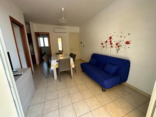 salon z niebieską kanapą i stołem w obiekcie Appartamenti Le 2M w mieście San Pietro in Bevagna