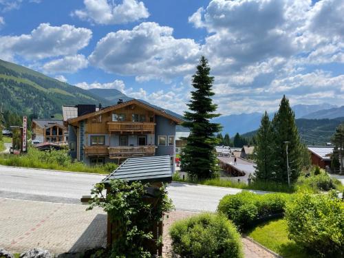 a house on the side of a road with a bench at Königsleiten Ski- und Wanderwohnung Top 40 an der Piste und Lift in Königsleiten