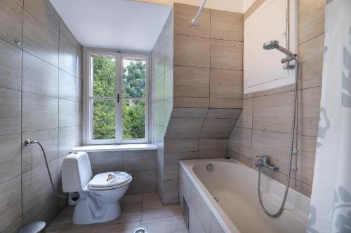 a bathroom with a toilet and a tub and a sink at Splendid View apartment Opatija in Opatija