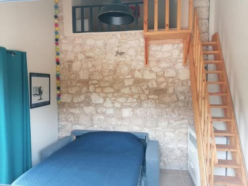 una camera con letto blu e parete in pietra di MAS GRATTELOUP, au calme, idéal pour les enfants a Monteux