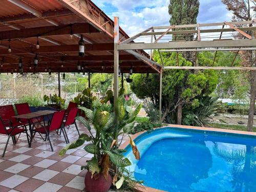 a patio with a pool and a table and chairs at Casa Vacacional Temixco in Temixco