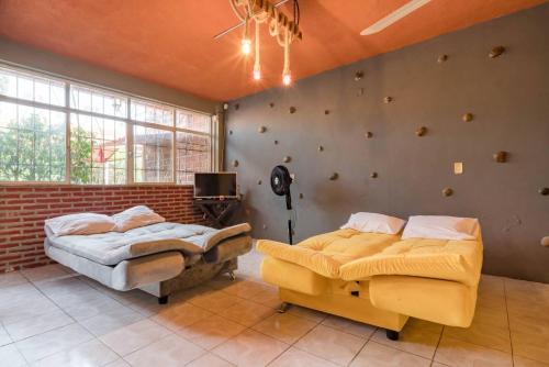 a bedroom with two beds and a tv in it at Casa Vacacional Temixco in Temixco