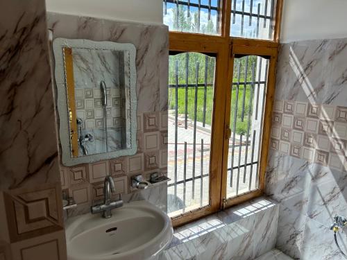 a bathroom with a sink and a window at Nature Palace Farmstay in Shey