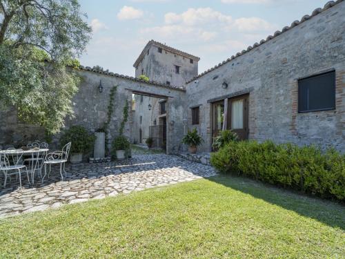 Elle offre une vue sur l'extérieur d'une maison en pierre dotée d'une terrasse. dans l'établissement Ancient holiday home in the countryside of Stilo with garden, à Guardavalle