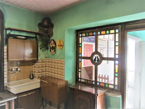 cocina con paredes verdes, lavabo y ventana en Casa Di Collina Nelle Langhe Typical country house, en Belvedere Langhe