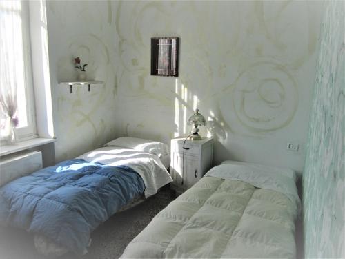 2 camas individuales en una habitación con ventana en Casa Di Collina Nelle Langhe Typical country house, en Belvedere Langhe