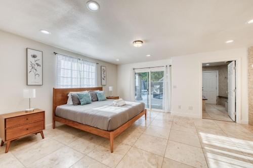 1 dormitorio con cama, mesa y ventana en Fig Garden 4BR House W Pool, en Fresno