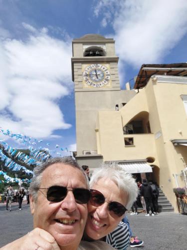 a man and woman standing in front of a clock tower at Casetta dell`Uliveto in Macchiascandona