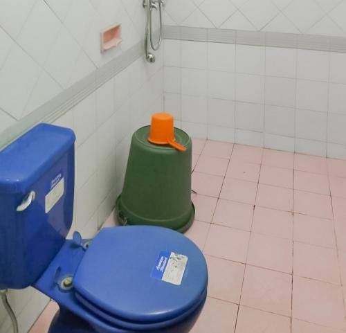 La salle de bains est pourvue de toilettes bleues. dans l'établissement Villa Anyelir Yustik Mitra RedDoorz, 