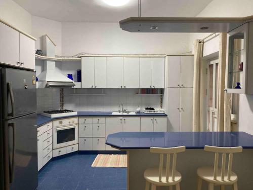 een keuken met een blauw aanrecht en witte kasten bij Lovely 3 Bedrooms Apartment at city center in Bayt Jālā