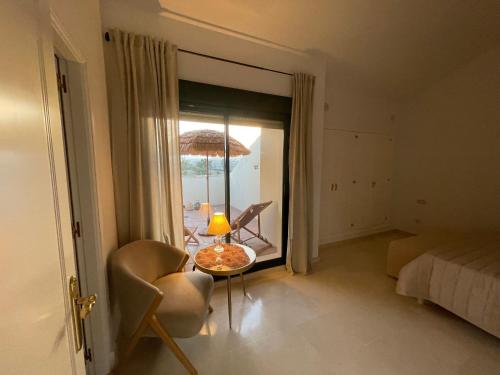 Habitación con cama y mesa con lámpara. en Casa de Loros en Marbella