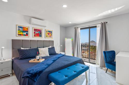a bedroom with a blue bed and a window at Morgan Residences 508A in Cabo San Lucas
