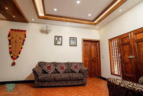 a living room with a couch and a ceiling at Vasthyam in Kenichira
