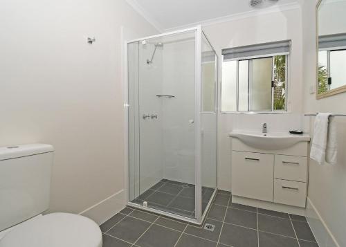 baño blanco con ducha y lavamanos en Coast Apartments Large 2 Bed 1 Bathroom with Pool, en Torquay