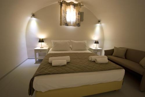 a bedroom with a large bed and a couch at Alafouzos Studios & Apartments in Kamari