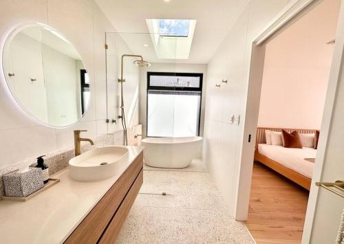 y baño con lavabo, bañera y espejo. en Amila - central location with designed spaces, en Dunsborough