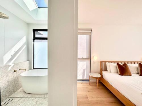 1 dormitorio con bañera y 1 cama con ventana en Amila - central location with designed spaces, en Dunsborough