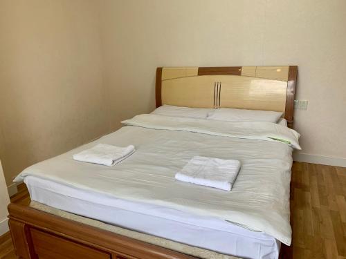 a large white bed with two towels on it at 2 bedrooms apartment in Ulaanbaatar
