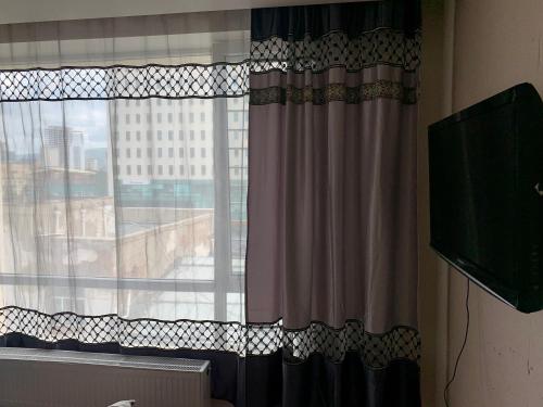 a room with a window with curtains and a television at 2 bedrooms apartment in Ulaanbaatar