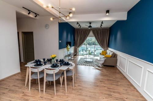 ein Esszimmer mit einem Tisch und einer blauen Wand in der Unterkunft Sunrise Terrace at Quintet (3BR/8 pax) in Tanah Rata