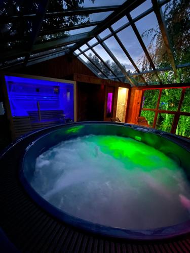 a large tub with green water in a room at Domki Platan w Karkonoszach in Kowary
