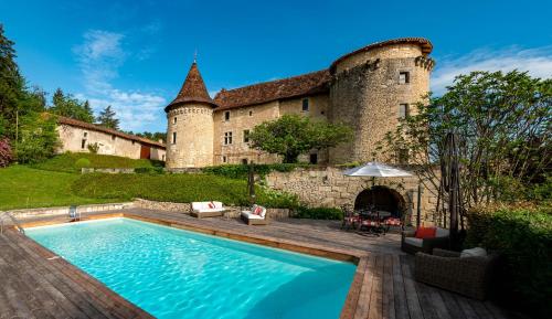 a house with a swimming pool in front of a building at Château de Belet in Saint-Aquilin