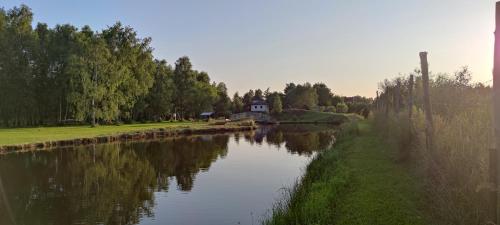 a river with a house in the middle of it at Owczarkowa Zagroda 