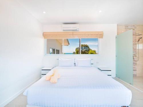 Villa Maviela Sea View 2 Bdr في كوه ساموي: غرفة نوم بيضاء مع سرير أبيض كبير مع نافذة