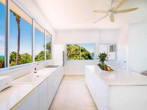 a white bathroom with two sinks and a ceiling fan at Villa Maviela Sea View 2 Bdr in Koh Samui 