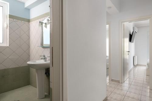 a bathroom with a sink and a toilet at White&Blue luxury suites in Ialyssos