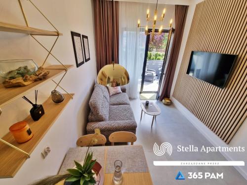 un soggiorno con divano e TV di Apartament ETNO LOFT 10 - 365PAM a Ustronie Morskie