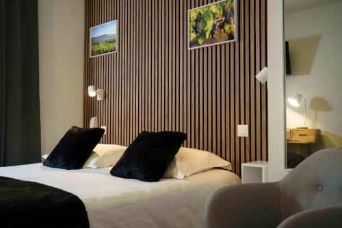 a bedroom with a bed with two black pillows at Hôtel Restaurant Le Moulin de Saint Verand in Saint-Vérand