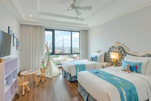una camera d'albergo con due letti e una finestra di Melia Vinpearl Quang Binh a Dong Hoi